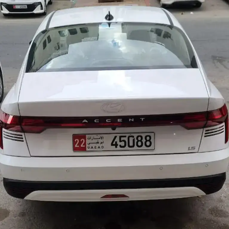 منظر خلفي لسيارة هيونداي اكسنت 2026 بيضاء للإيجار بسعر اقتصادي في أبوظبي